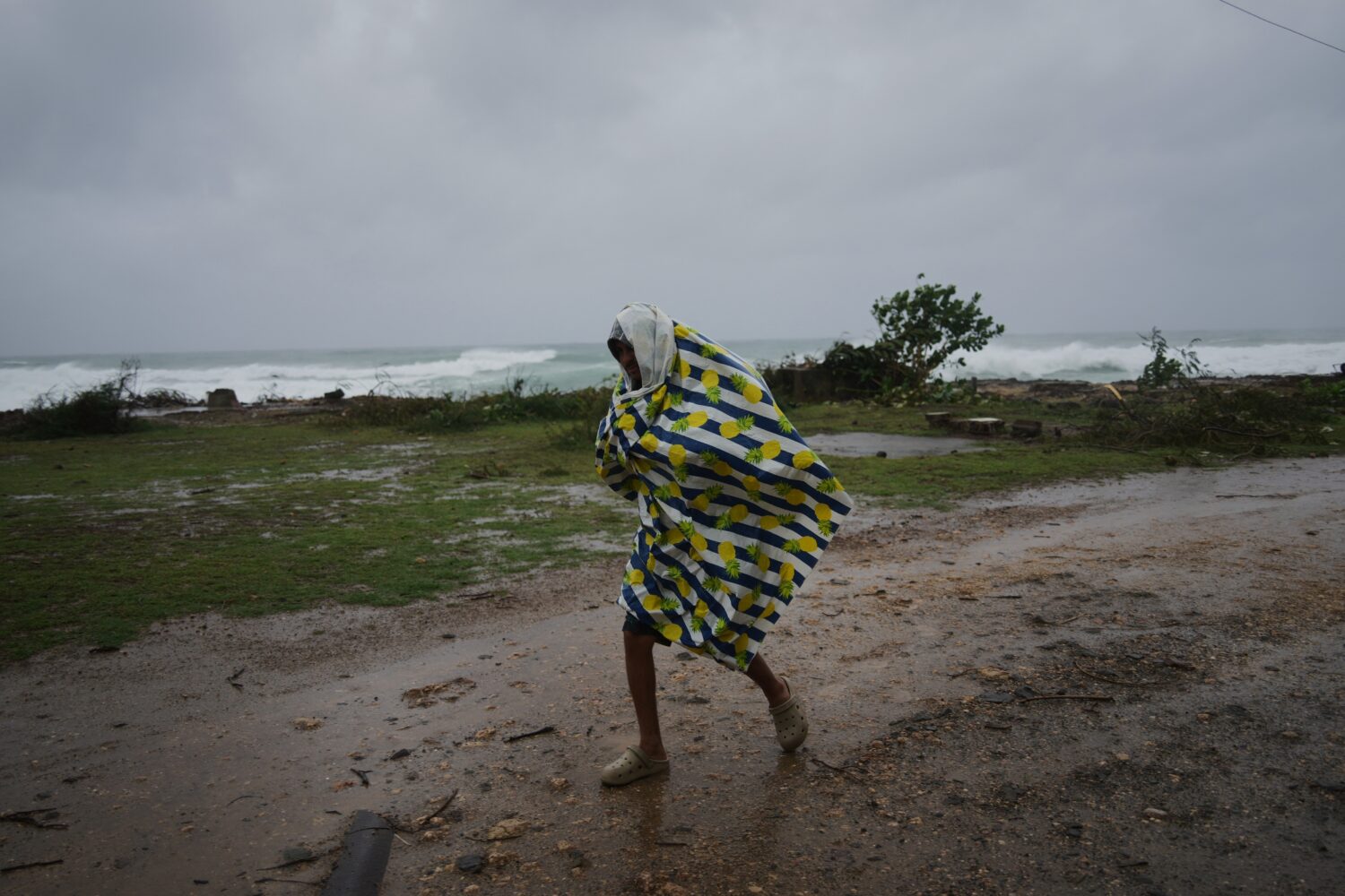 A man walks in the rain before the arrival of Hurricane Melissa in Canizo, a village in Santiago de...