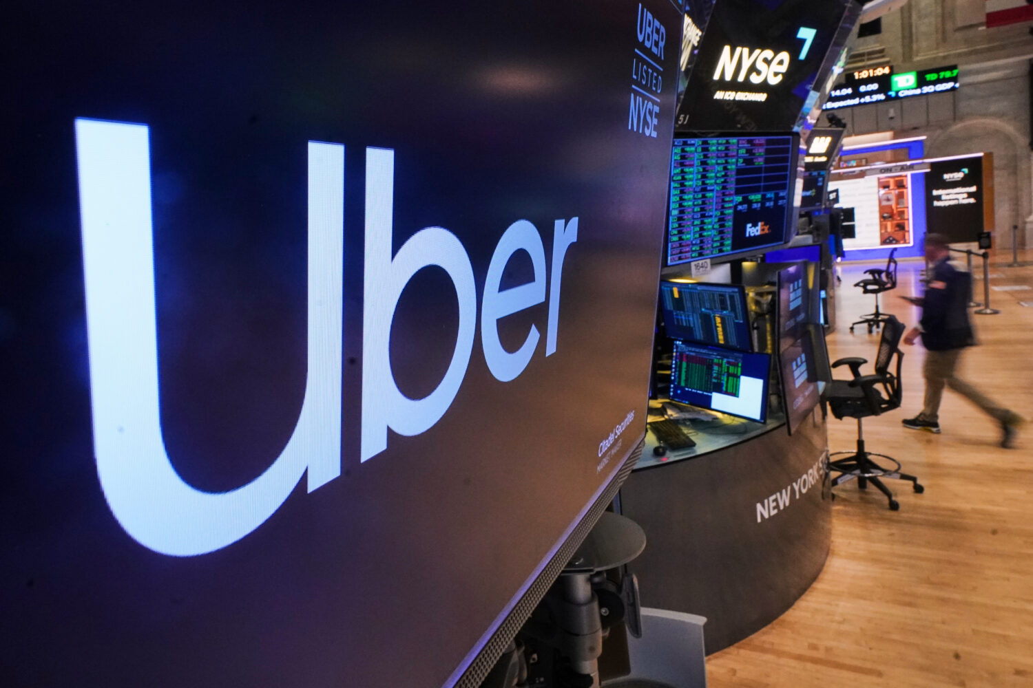 The logo for Uber is displayed above a trading post on the floor of the New York Stock Exchange, Mo...